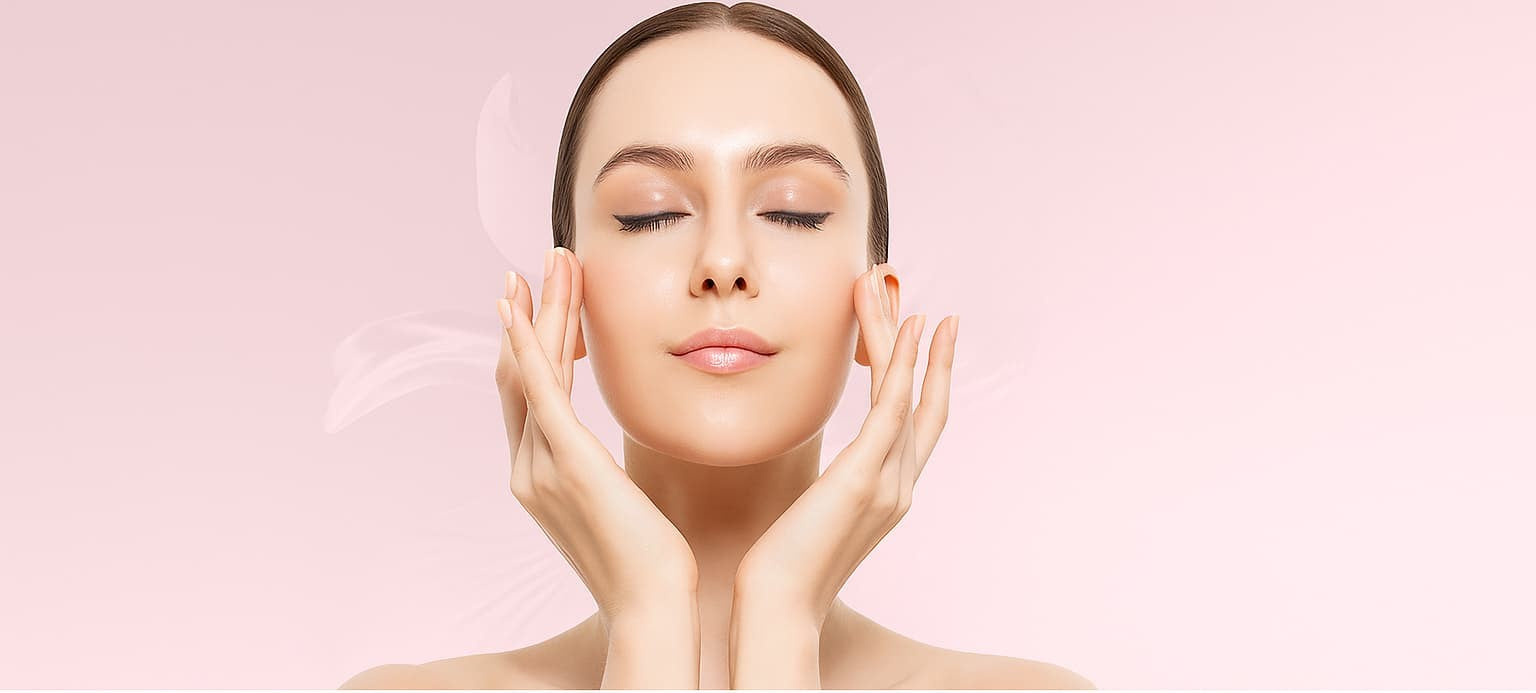 Woman touching her face against a pink background